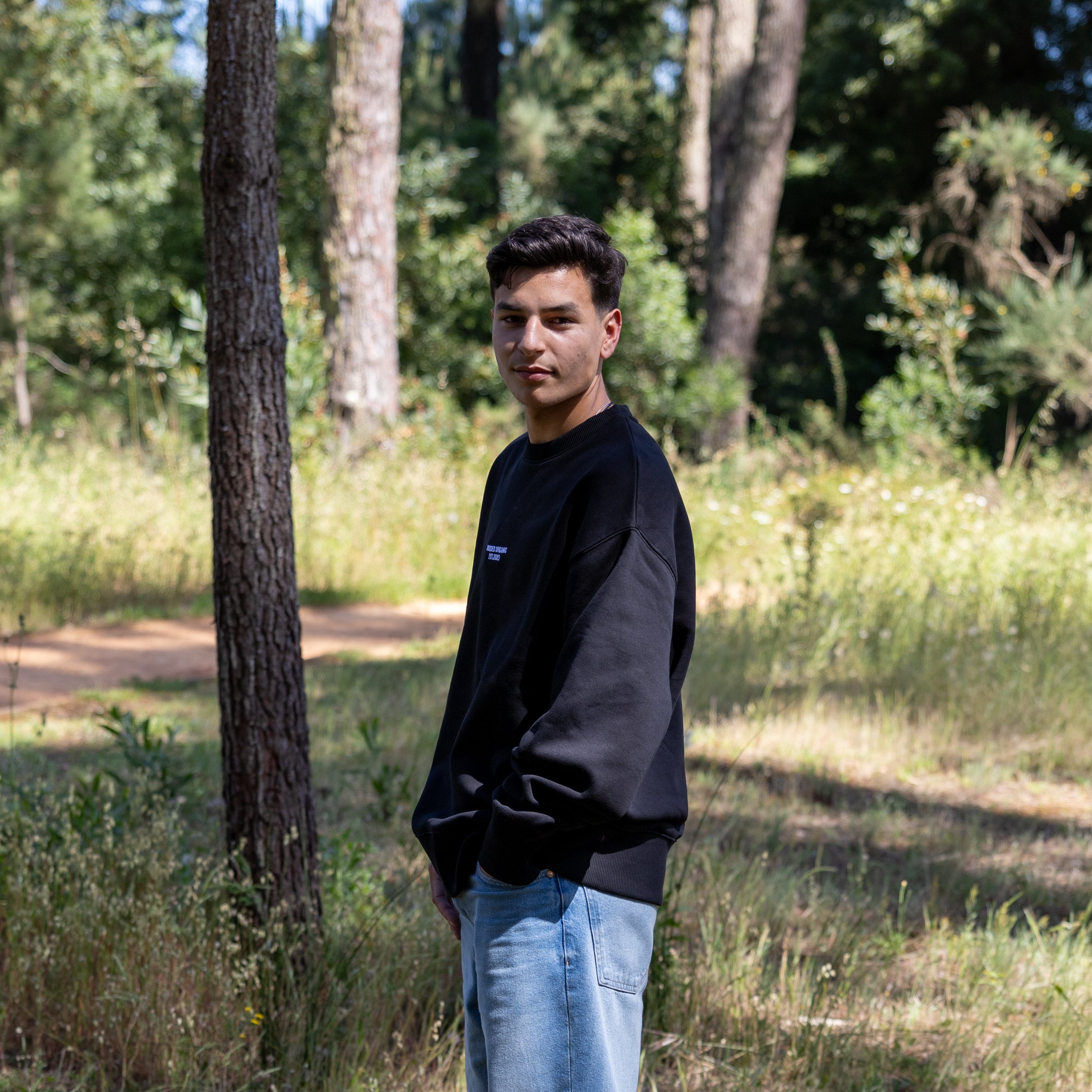 Sideprofil af sort sweatshirt – 100% økologisk bomuld og afslappet pasform
